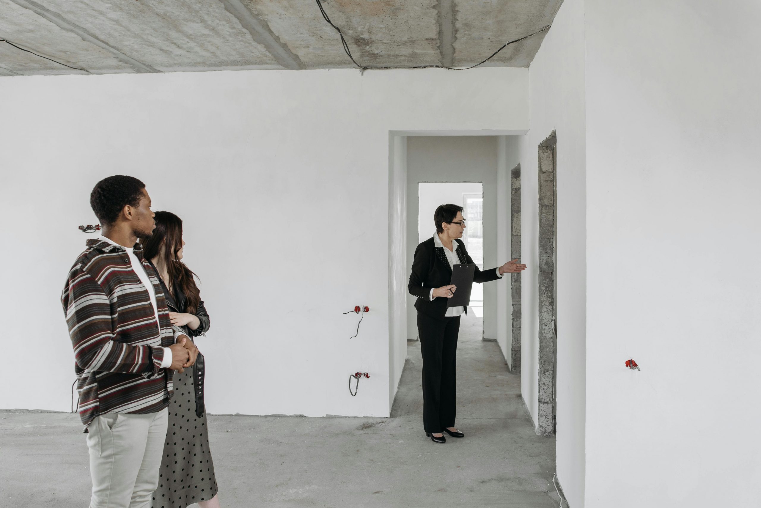 Couple exploring a house that is still under construction with a real estate agent. 