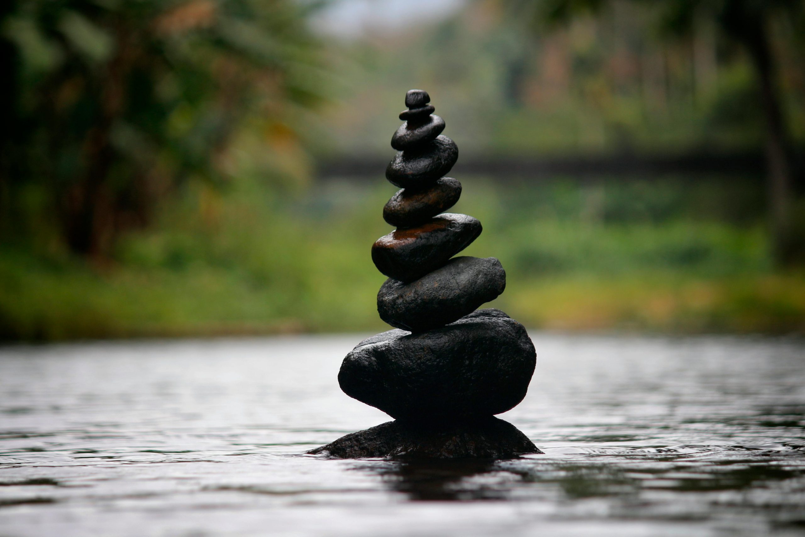 Rocks balancing in a river, stacked on top of each other. 