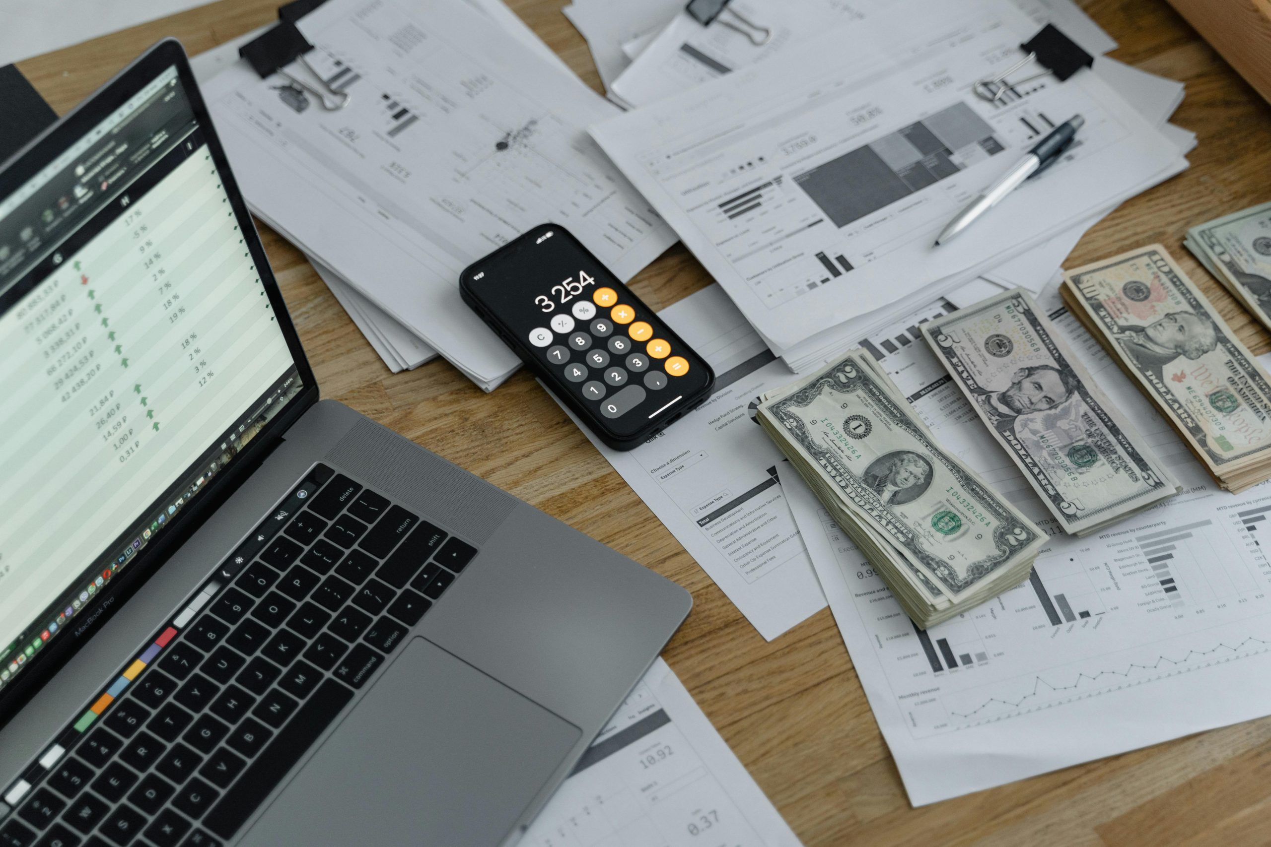 Banknotes and calculator on the table, reviewing finances. 